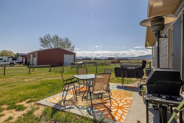 4175 Mchugh Ln, Helena, MT 59602 - view of patio / terrace with a detached garage, a mountain view, an outbuilding, and grilling area