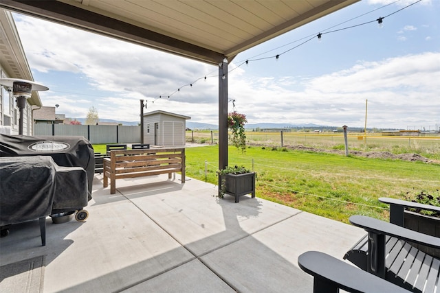 1317 Creekside Dr, Stevensville, MT 59870 - view of patio featuring a view of countryside, a storage shed, an outbuilding, and a grill