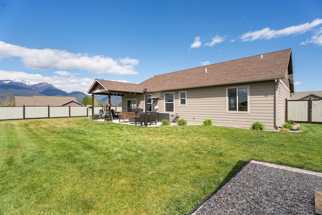 1317 Creekside Dr, Stevensville, MT 59870 - back of property featuring a patio area, a mountain view, and a shingled roof