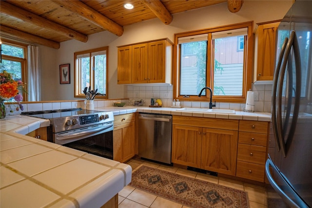 281 Eagle Bend Dr, Bigfork, MT 59911 - kitchen featuring appliances with stainless steel finishes, a wood ceiling with exposed beams, tasteful backsplash, tile counters, and recessed lighting