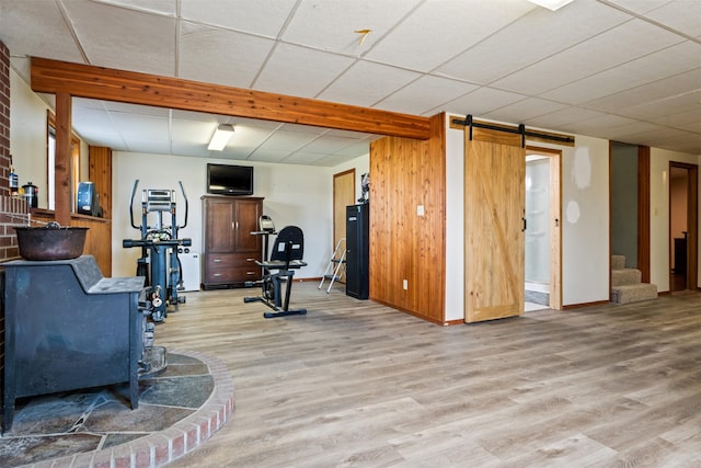 445 Sapphire Ln, Stevensville, MT 59870 - exercise area with light wood-style flooring, a barn door, and a wood stove