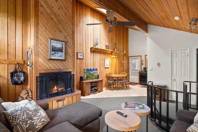 74 Limber Pne, Whitefish, MT 59937 - living area featuring a lit fireplace, wood finished floors, wood walls, a ceiling fan, and high vaulted ceiling