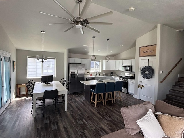 2195 Black Bird Ln, Kalispell, MT 59901 - living room with lofted ceiling, dark wood finished floors, ceiling fan, stairs, and a chandelier