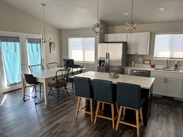 2195 Black Bird Ln, Kalispell, MT 59901 - kitchen with appliances with stainless steel finishes, vaulted ceiling, light countertops, dark wood-type flooring, and a kitchen island