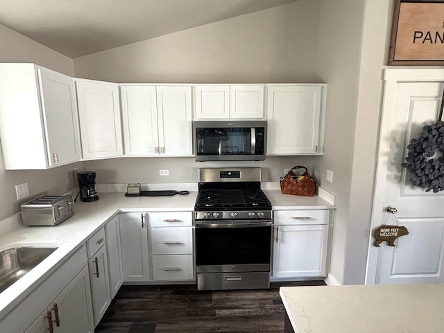 2195 Black Bird Ln, Kalispell, MT 59901 - kitchen with appliances with stainless steel finishes, vaulted ceiling, dark wood finished floors, light countertops, and white cabinetry