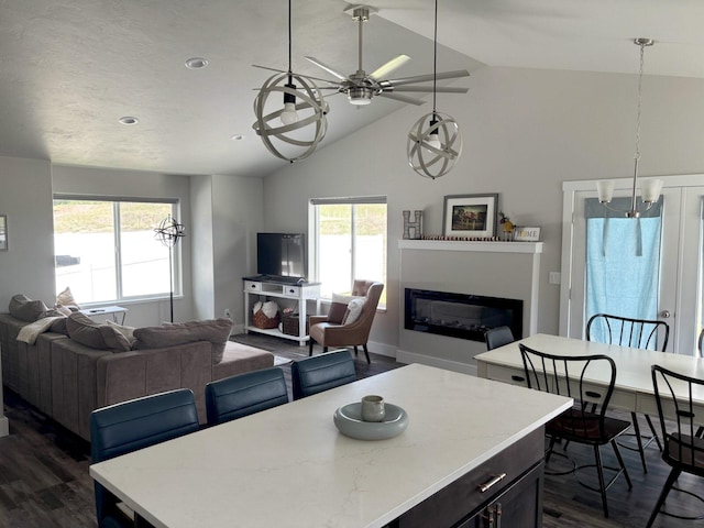 2195 Black Bird Ln, Kalispell, MT 59901 - dining room with dark wood-style flooring, a glass covered fireplace, ceiling fan, and high vaulted ceiling