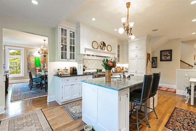 145 E Beckwith Ave, Missoula, MT 59801 - kitchen featuring a chandelier, baseboards, tasteful backsplash, white cabinets, and premium range hood
