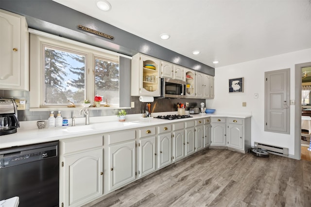 kitchen featuring dishwasher, a sink, a baseboard heating unit, stainless steel microwave, and gas stovetop