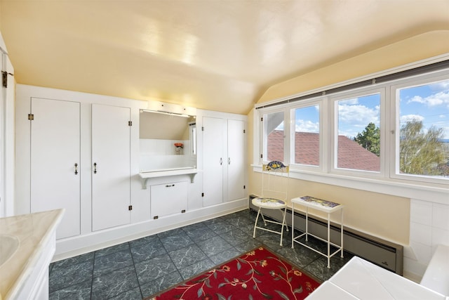 interior space featuring vaulted ceiling and a baseboard heating unit
