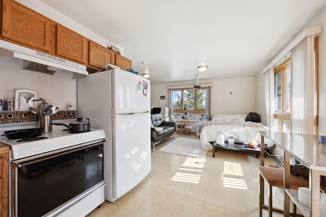 kitchen featuring white appliances, open floor plan, brown cabinetry, and under cabinet range hood