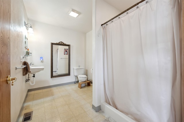 full bathroom with toilet, tile patterned floors, baseboards, and a shower with shower curtain