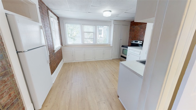 29 3rd Ave E, Kalispell, MT 59901 - kitchen featuring freestanding refrigerator, stainless steel electric stove, brick wall, light wood-type flooring, and a paneled ceiling