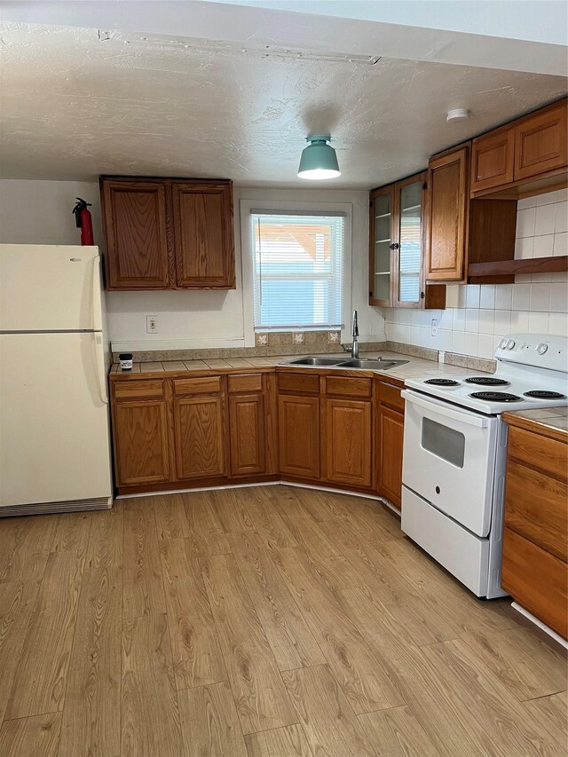 29 3rd Ave E, Kalispell, MT 59901 - kitchen with white appliances, light wood-type flooring, brown cabinets, and light countertops