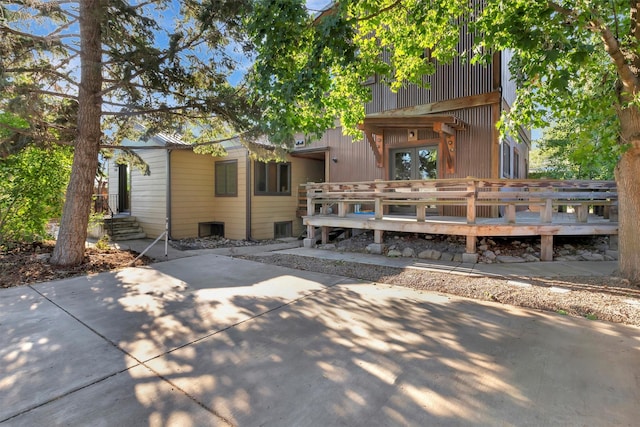 rear view of property featuring a balcony and a deck