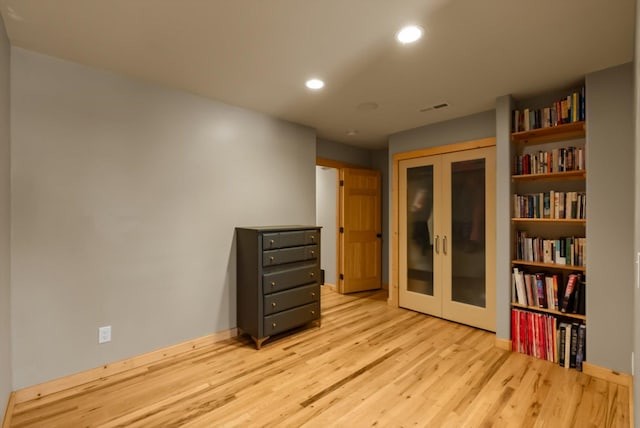 spare room featuring french doors, wood finished floors, recessed lighting, and baseboards