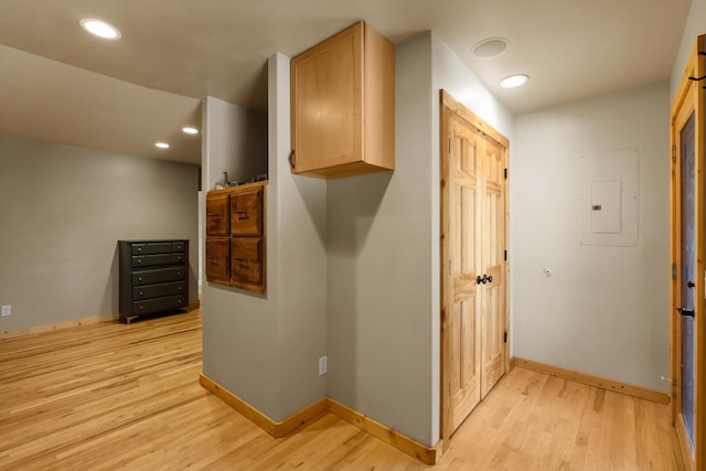 hallway with light wood-style floors, baseboards, recessed lighting, and electric panel