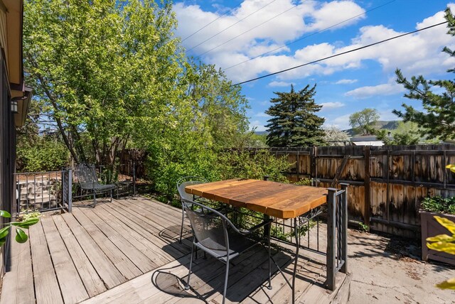 wooden terrace featuring a fenced backyard and outdoor dining area
