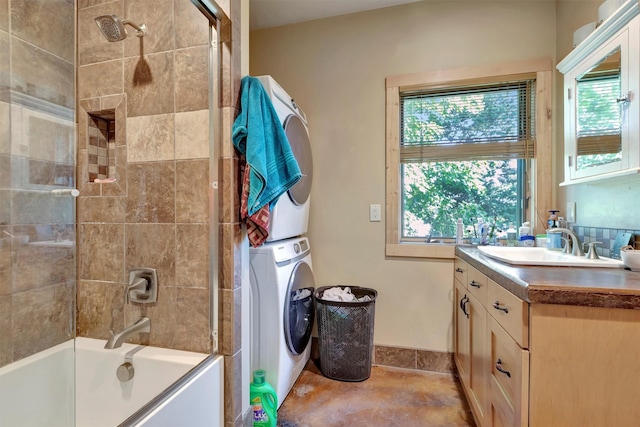 bathroom featuring stacked washer and clothes dryer, vanity, shower / bathtub combination, and baseboards