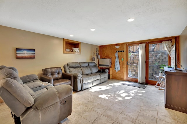 living area featuring recessed lighting, wood walls, a textured ceiling, and light tile patterned floors