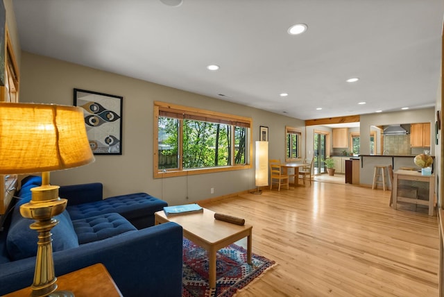 living area with light wood-style flooring, recessed lighting, and baseboards