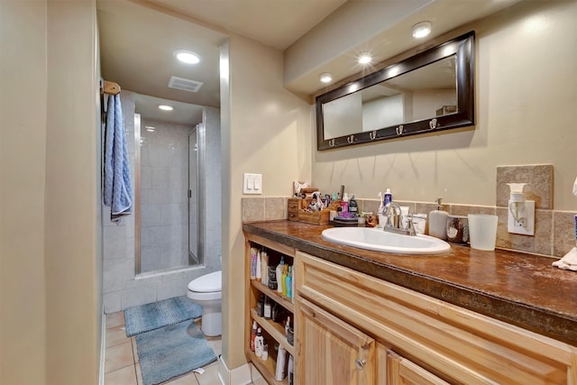 bathroom with toilet, tiled shower, tile patterned flooring, vanity, and recessed lighting
