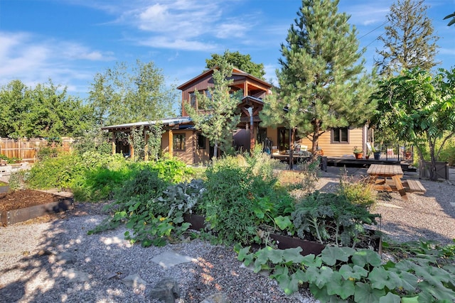 back of house featuring a wooden deck and fence