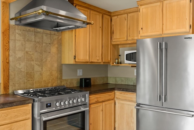 kitchen featuring stainless steel appliances, island exhaust hood, dark countertops, and tasteful backsplash