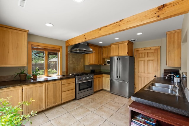 kitchen featuring appliances with stainless steel finishes, wall chimney exhaust hood, a sink, dark countertops, and recessed lighting