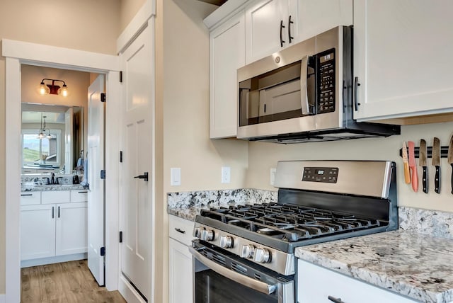 7047 Shaver Dr Unit B, Missoula, MT 59803 - kitchen featuring stainless steel appliances, white cabinets, and light stone countertops