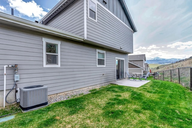 7047 Shaver Dr Unit B, Missoula, MT 59803 - rear view of property featuring central AC unit, a patio area, a mountain view, and board and batten siding
