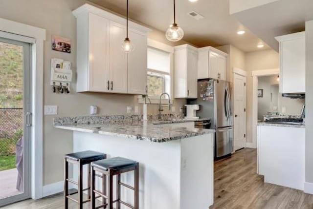 7047 Shaver Dr Unit B, Missoula, MT 59803 - kitchen featuring a peninsula, white cabinetry, a kitchen bar, and recessed lighting
