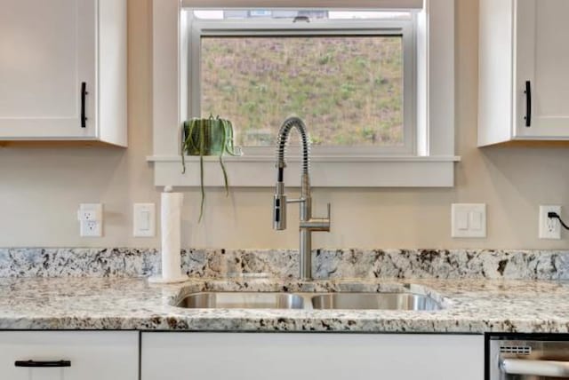 7047 Shaver Dr Unit B, Missoula, MT 59803 - kitchen view of a sink, dishwasher, white cabinets, and light stone countertops