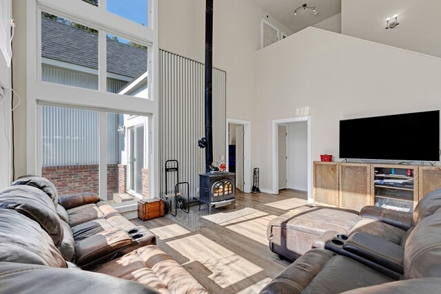 11327 Sleeman Ln, Lolo, MT 59847 - living area with a towering ceiling, a wood stove, wood finished floors, and baseboards