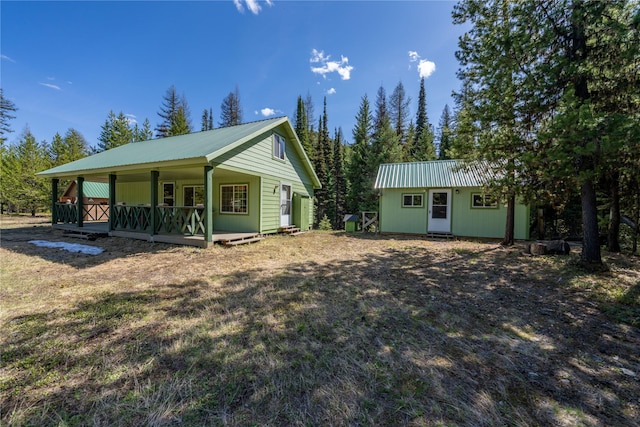 4320 E Fisher River Rd, Libby, MT 59923 - rear view of house with an outbuilding, a porch, and metal roof