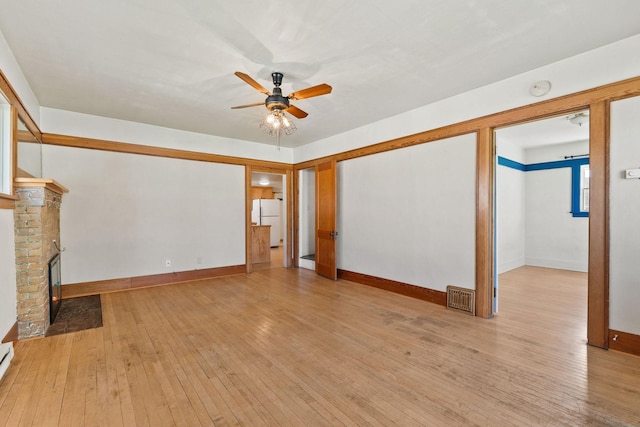 427 Somers Ave, Whitefish, MT 59937 - unfurnished living room with ceiling fan, hardwood / wood-style flooring, and a brick fireplace