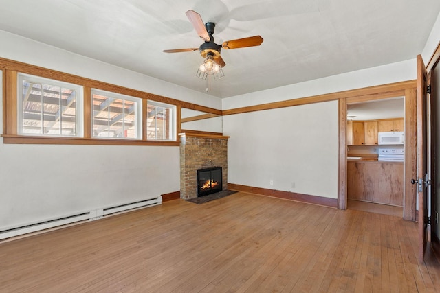 427 Somers Ave, Whitefish, MT 59937 - unfurnished living room featuring a baseboard heating unit, wood-type flooring, ceiling fan, and a fireplace