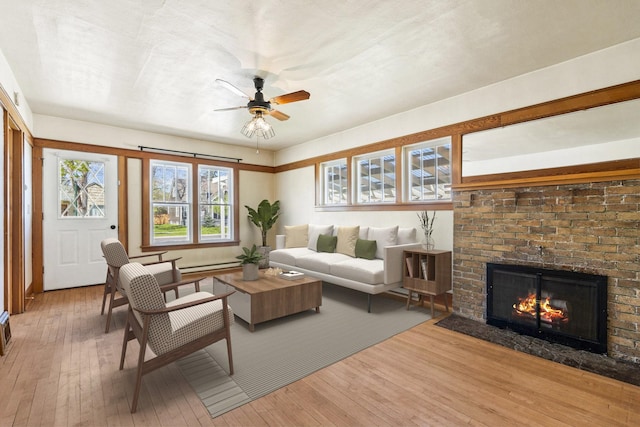 427 Somers Ave, Whitefish, MT 59937 - living area with hardwood / wood-style flooring, a baseboard radiator, ceiling fan, and a brick fireplace