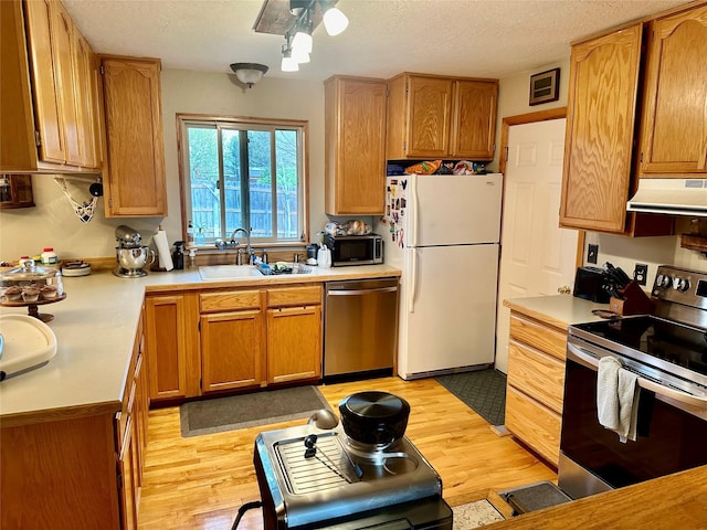 146 New Meadows Dr, Missoula, MT 59808 - kitchen featuring stainless steel appliances, under cabinet range hood, light countertops, and a textured ceiling