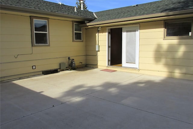 back of property featuring a patio and a shingled roof