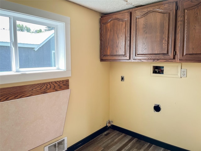 613 Minnesota Ave, Libby, MT 59923 - washroom with electric dryer hookup, cabinet space, washer hookup, and dark wood-type flooring