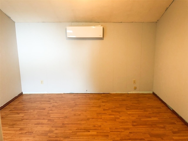 613 Minnesota Ave, Libby, MT 59923 - unfurnished room with an AC wall unit and wood finished floors