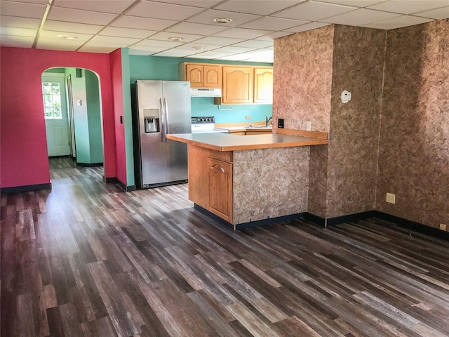 613 Minnesota Ave, Libby, MT 59923 - kitchen with appliances with stainless steel finishes, under cabinet range hood, dark wood-type flooring, arched walkways, and a paneled ceiling