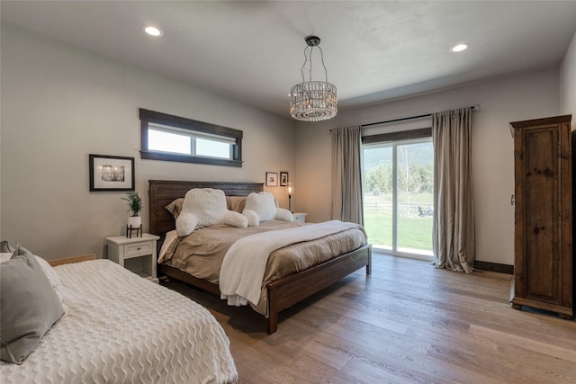 29 Elk Run Trl, Kalispell, MT 59901 - bedroom with access to exterior, wood finished floors, recessed lighting, and a chandelier