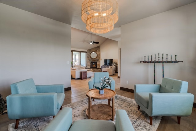 29 Elk Run Trl, Kalispell, MT 59901 - living room with a chandelier, lofted ceiling, wood finished floors, ceiling fan, and a stone fireplace