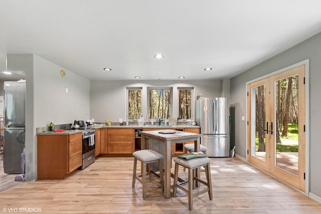 kitchen with appliances with stainless steel finishes, french doors, plenty of natural light, and recessed lighting