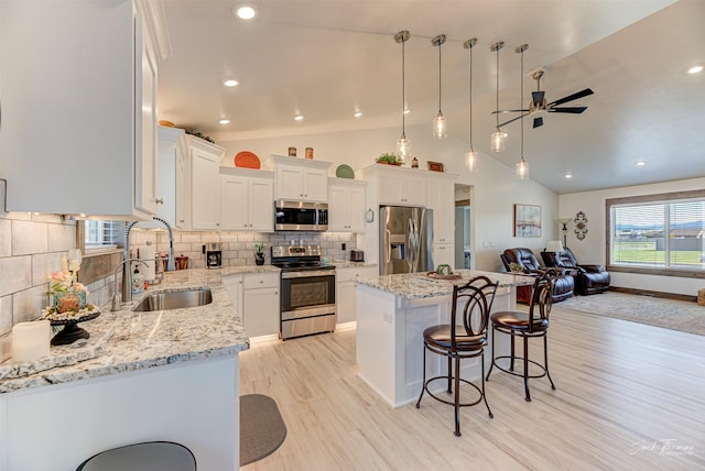 2966 Vermillion Way E, Helena, MT 59635 - kitchen featuring appliances with stainless steel finishes, ceiling fan, open floor plan, a breakfast bar area, and white cabinets