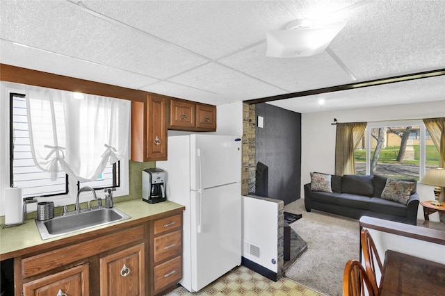 1320 1st Ave S, Great Falls, MT 59401 - kitchen with a sink, freestanding refrigerator, light countertops, brown cabinets, and a textured ceiling