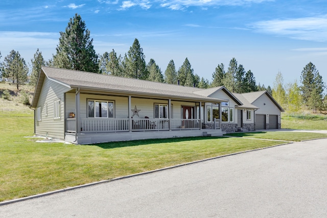 ranch-style home featuring a porch, driveway, a front yard, and an attached garage