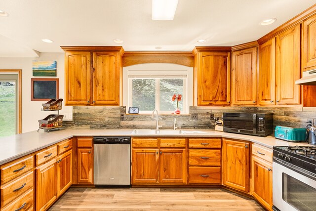 kitchen with appliances with stainless steel finishes, plenty of natural light, light countertops, tasteful backsplash, and recessed lighting