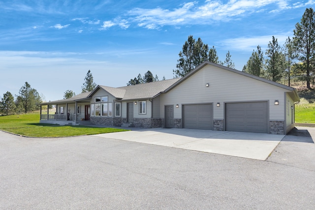 ranch-style home with driveway, an attached garage, stone siding, and a front lawn